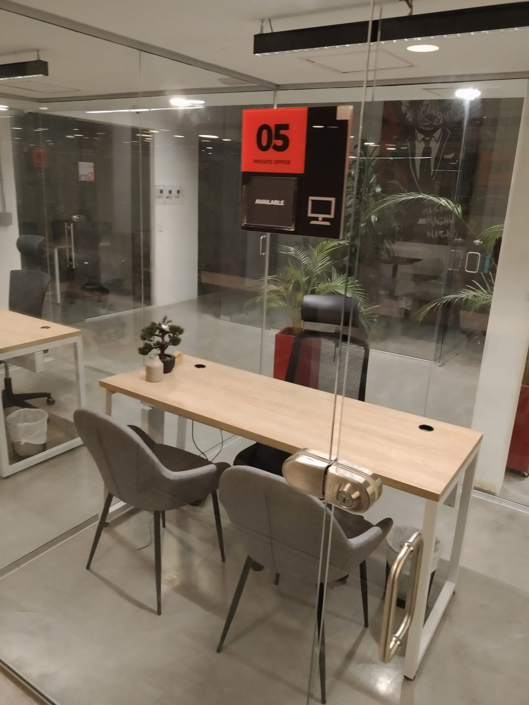 Glass private office with a desk and two chairs