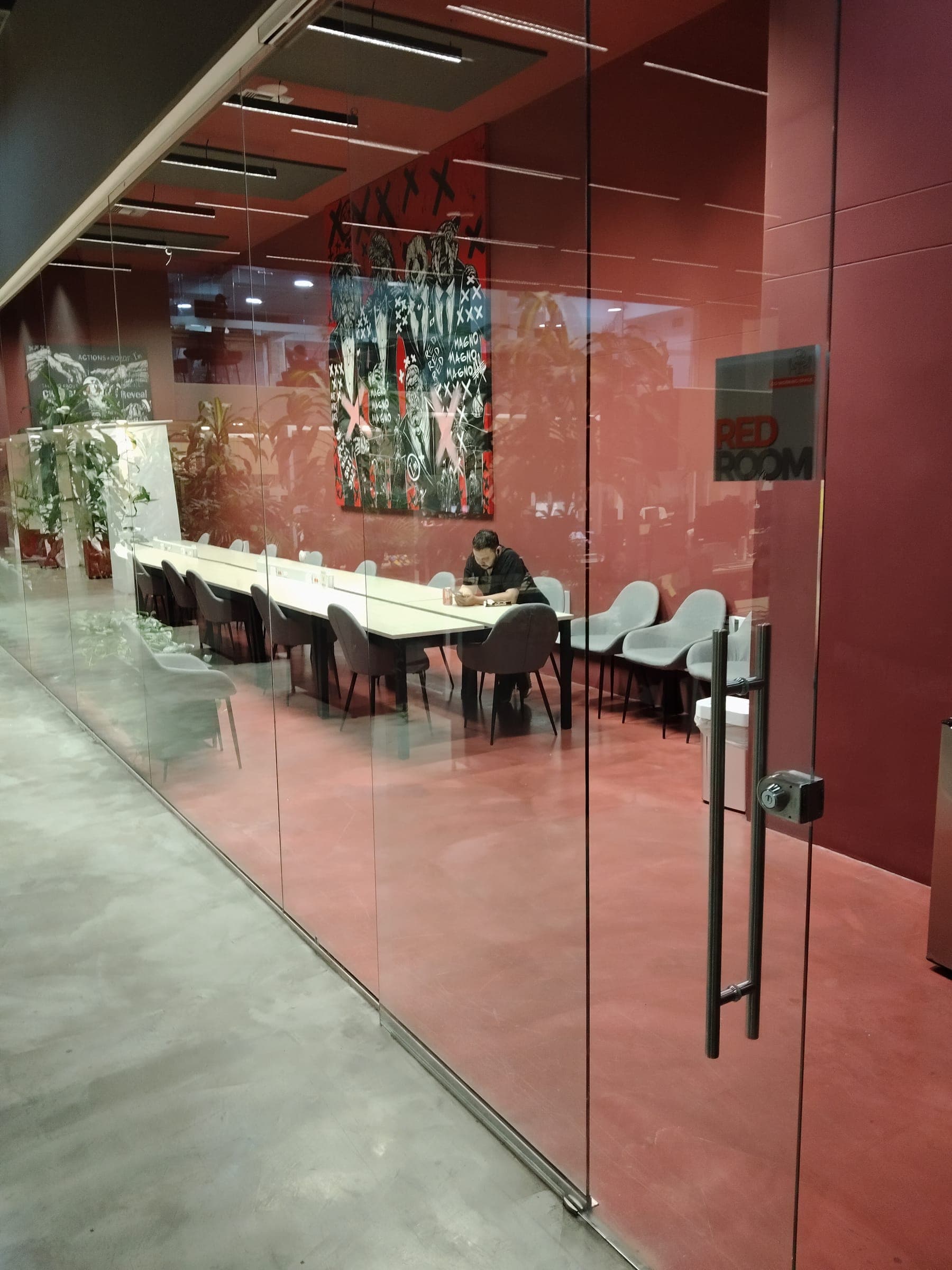 The Red Room, a red-walled space with a long shared work table